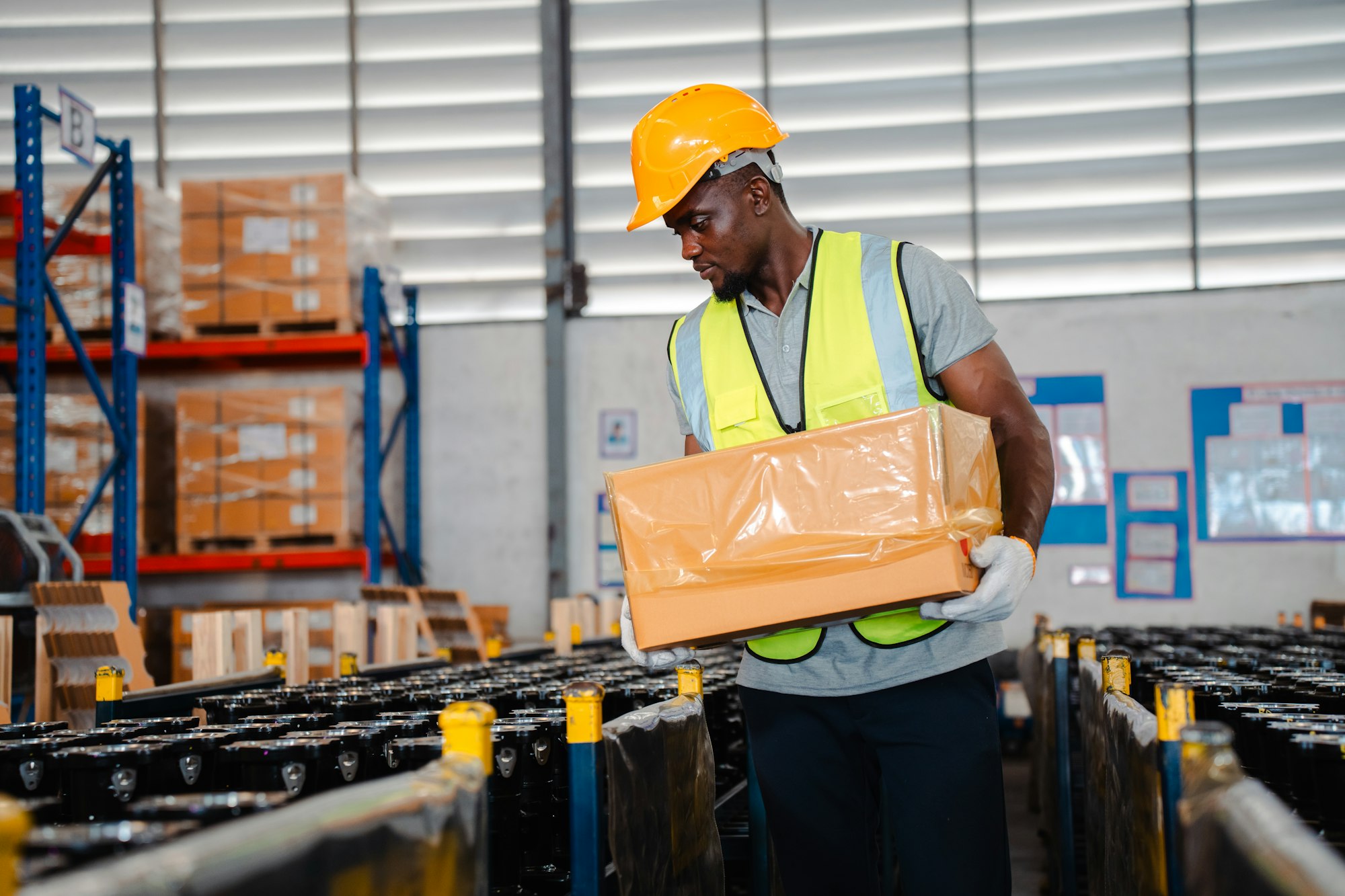 African American person working to shipping box package by order in logistic warehouse